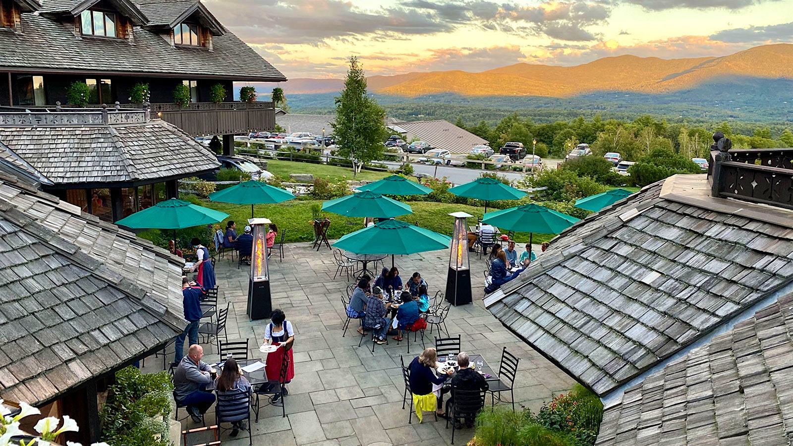 People dining outside at Trapp Family Lodge, with mountains in the background